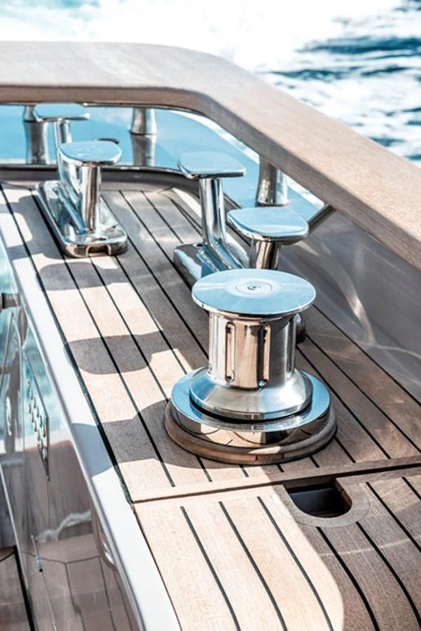 A close-up view of the yacht's deck showcasing polished stainless steel cleats and winches against a teak surface. aboard FATSA Yacht for Sale