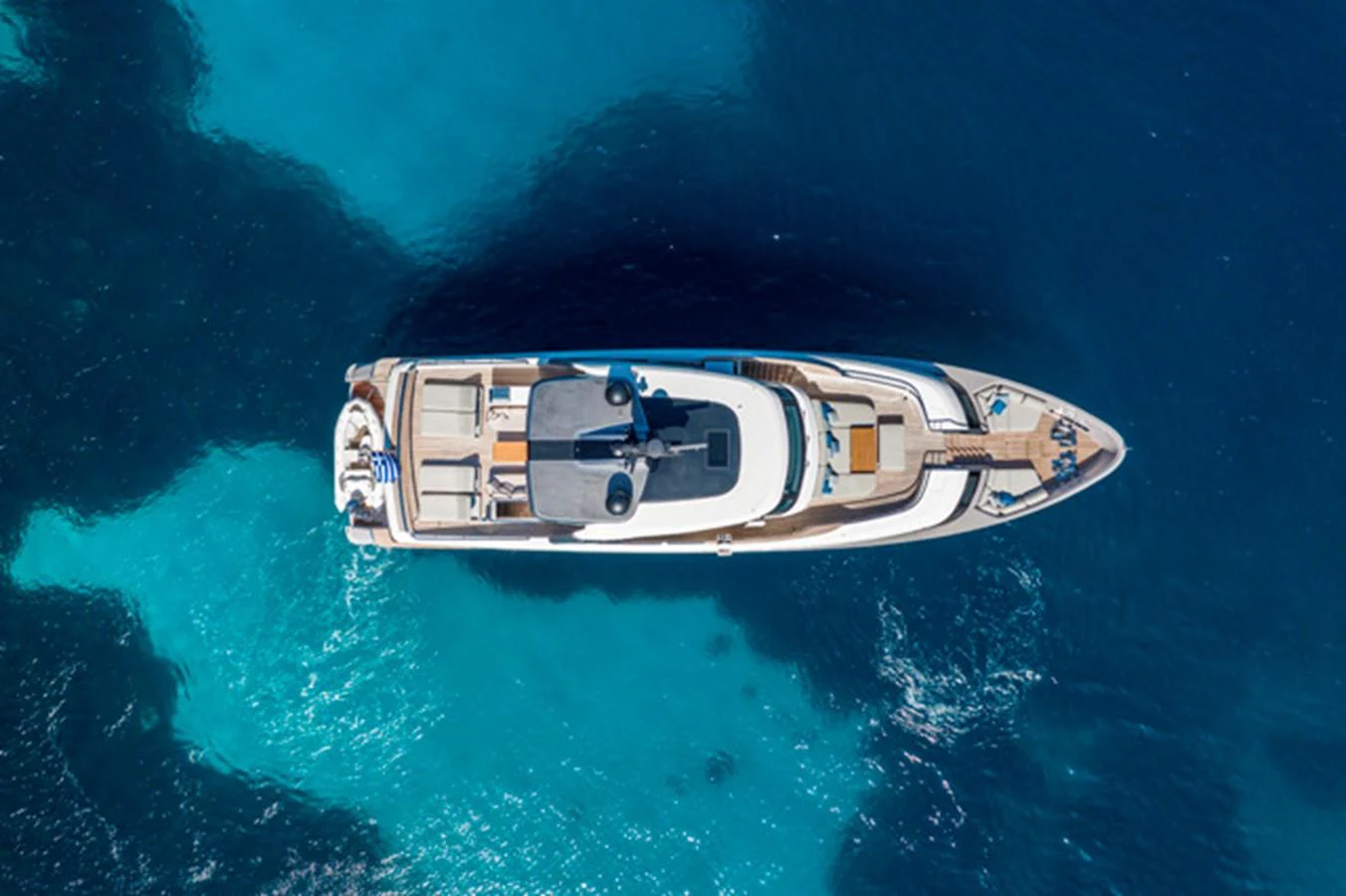 A stunning aerial view of a luxurious yacht cruising in clear blue waters. aboard FATSA Yacht for Sale