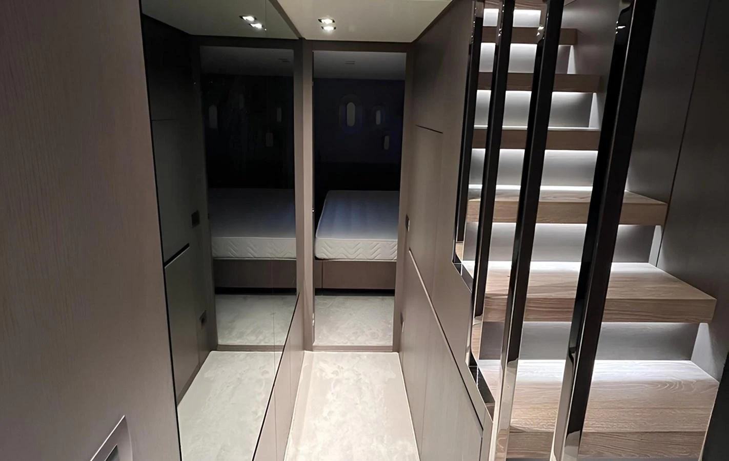 A modern yacht interior featuring a sleek staircase and a glimpse of a cozy cabin. aboard LYDIA Yacht for Sale