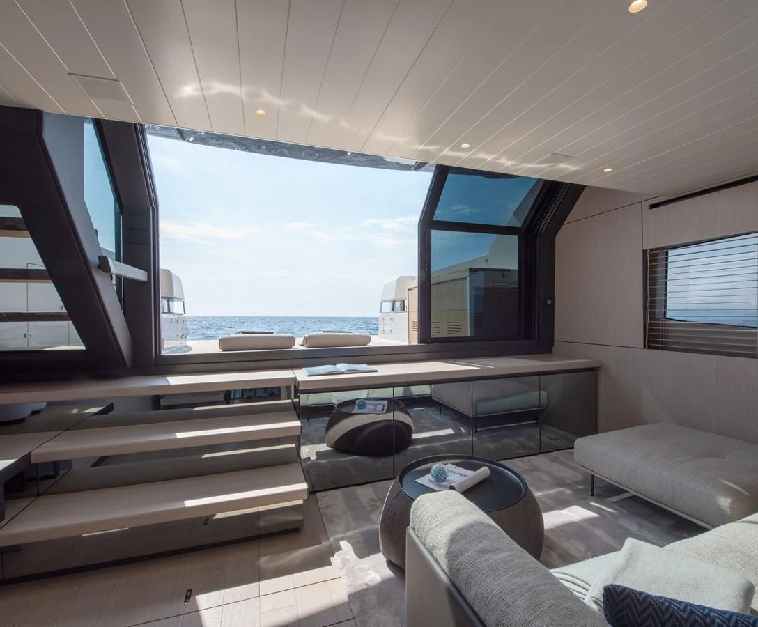 The salon offers a spacious and modern interior with large windows providing stunning ocean views. aboard BLUEGAME BGX63 #49 Yacht for Sale
