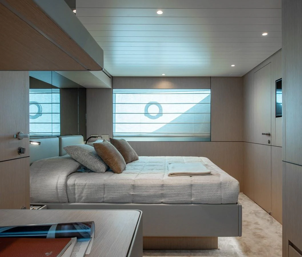 A luxurious stateroom featuring a large bed, modern design, and ample natural light. aboard BLUEGAME BGX63 #49 Yacht for Sale