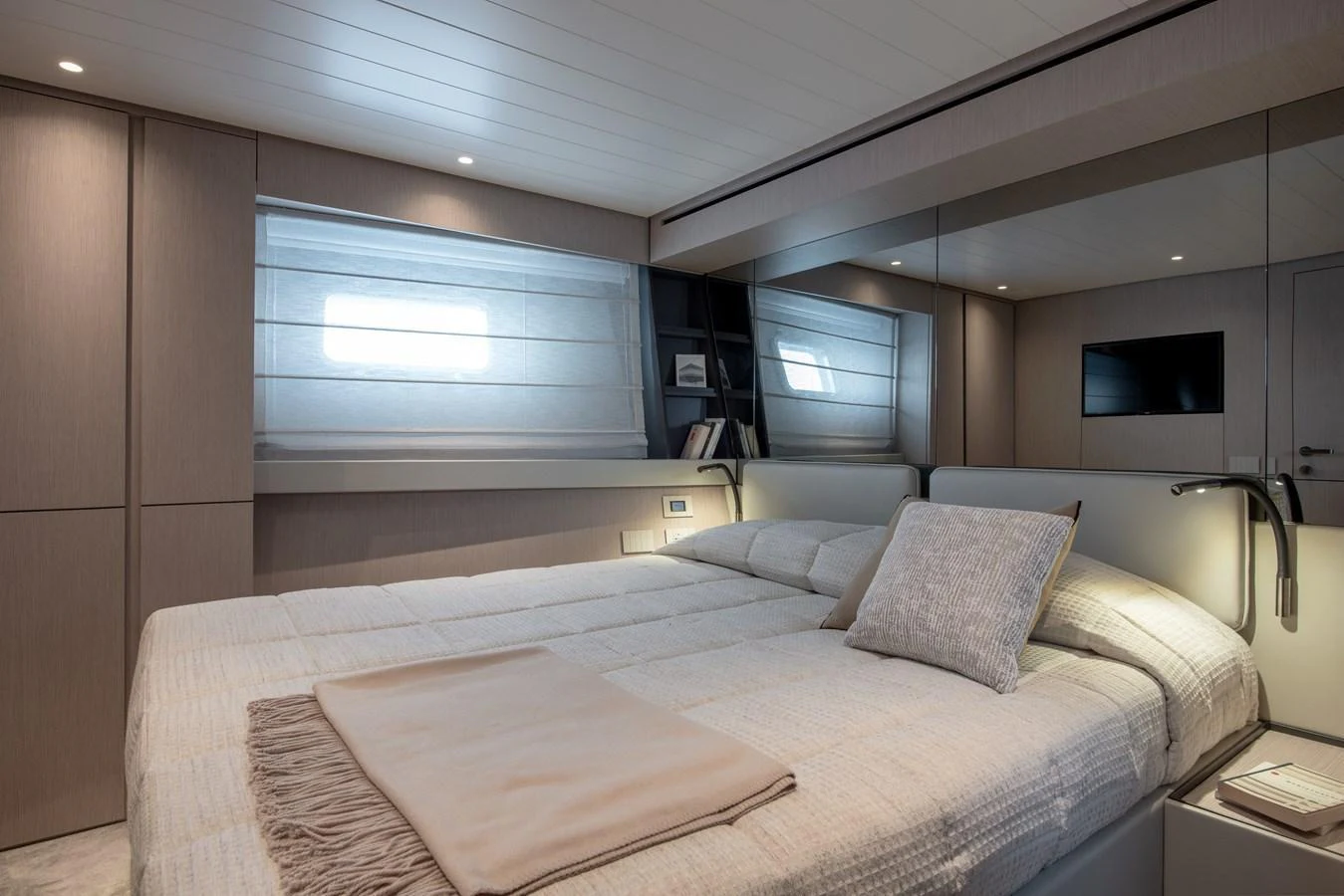 A luxurious stateroom featuring a large bed, modern lighting, and a serene ambiance. aboard BLUEGAME BGX63 #49 Yacht for Sale