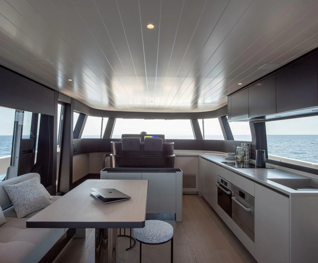 The yacht's galley features modern appliances and a sleek design, with ample natural light streaming through large windows. aboard BLUEGAME BGX63 #49 Yacht for Sale
