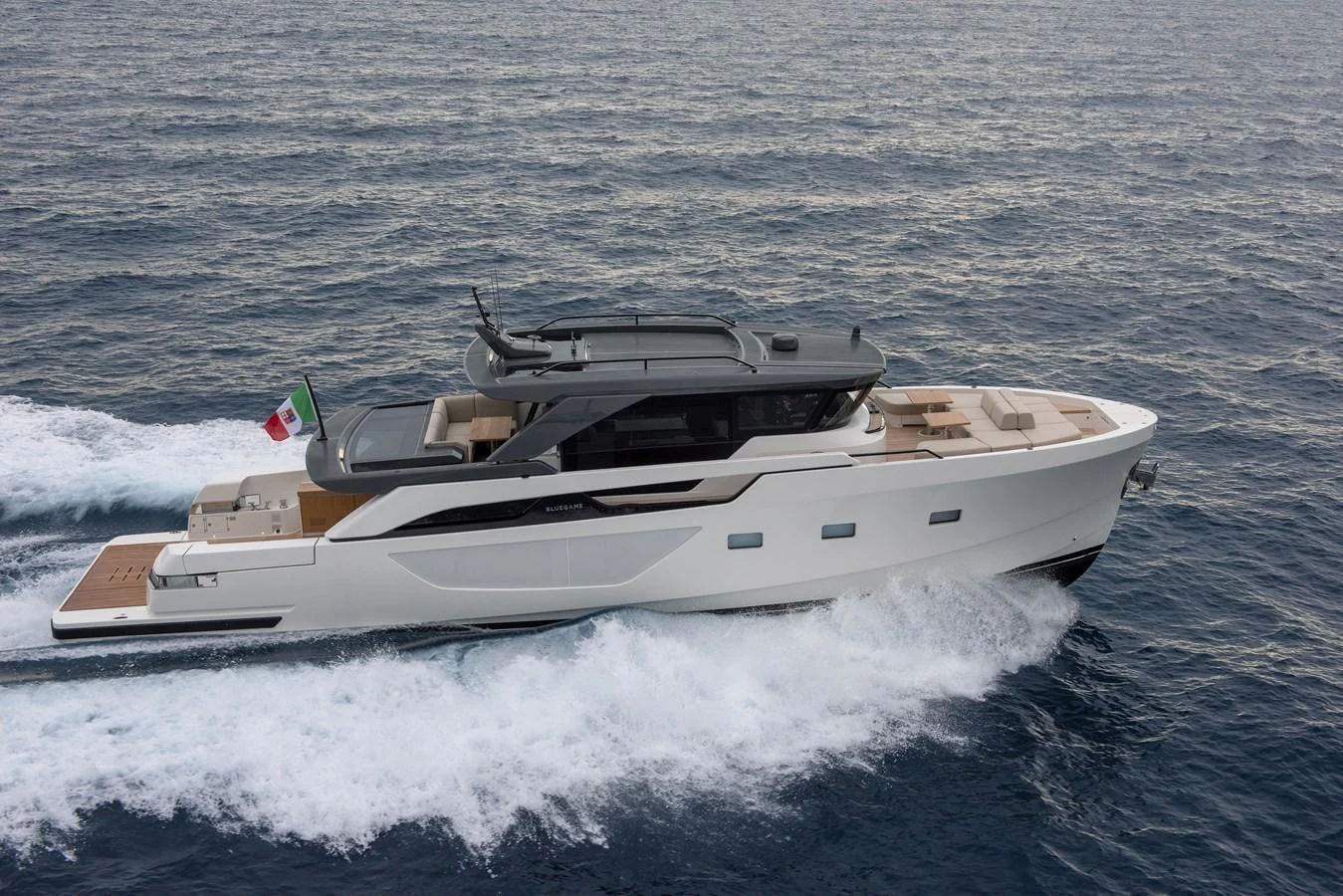 A sleek, modern yacht cruises swiftly through the open sea, showcasing its elegant design and spacious deck areas. aboard BLUEGAME BGX63 #49 Yacht for Sale