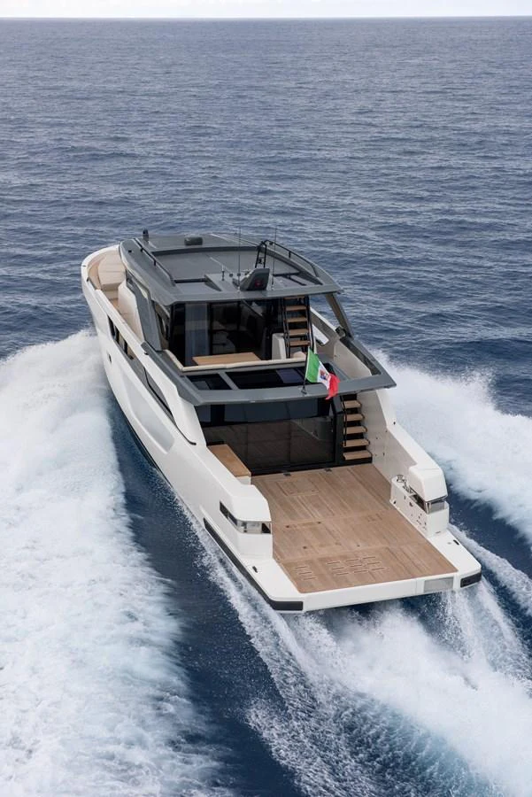 A sleek, modern yacht cruises swiftly through the open sea, showcasing its spacious aft deck. aboard BLUEGAME BGX63 #49 Yacht for Sale