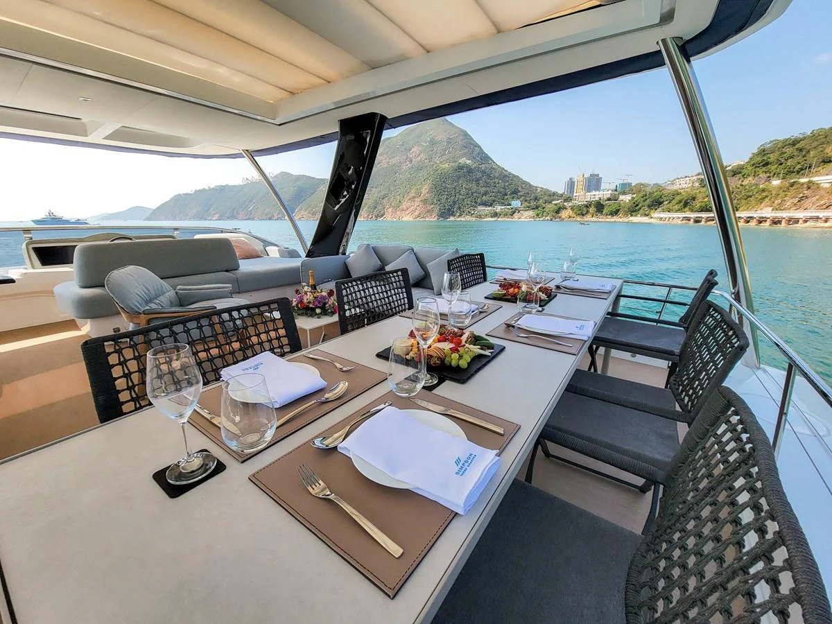 The alfresco dining area offers a picturesque setting with a view of the sea and surrounding landscape. aboard LAGOON SIXTY 7 Yacht for Sale