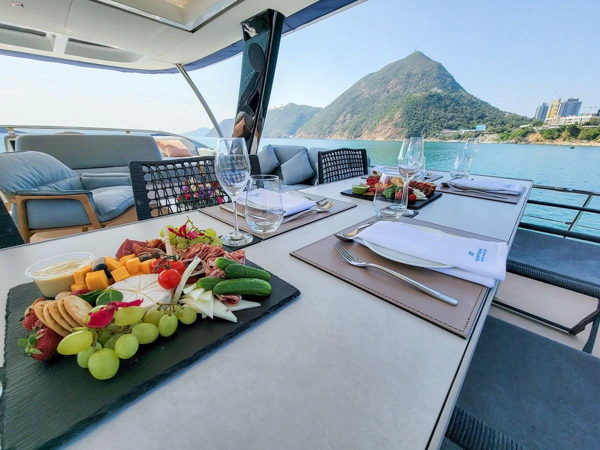 The alfresco dining area offers a picturesque setting with a beautifully set table and stunning views of the surrounding landscape. aboard LAGOON SIXTY 7 Yacht for Sale