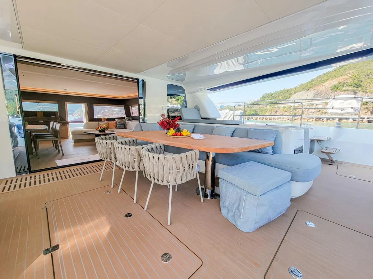 The aft deck features a spacious dining area with a large table and comfortable seating, perfect for alfresco meals. aboard LAGOON SIXTY 7 Yacht for Sale