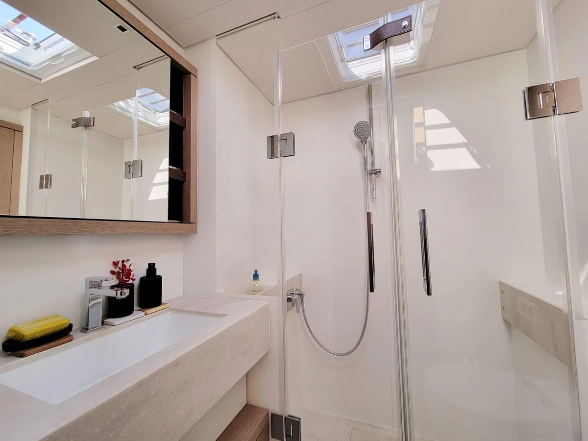 A modern yacht bathroom featuring a sleek shower and elegant fixtures. aboard LAGOON SIXTY 7 Yacht for Sale