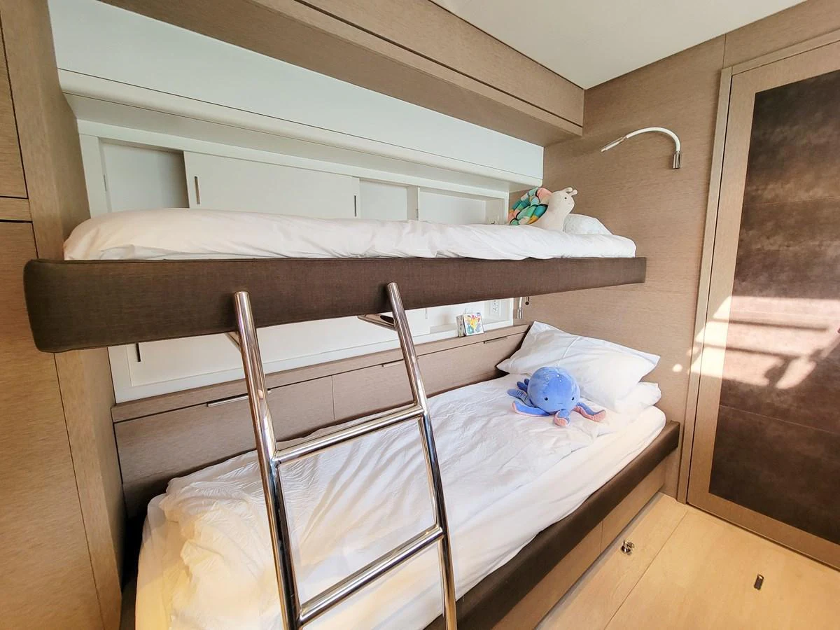 The guest cabin features cozy bunk beds with soft lighting and plush toys. aboard LAGOON SIXTY 7 Yacht for Sale