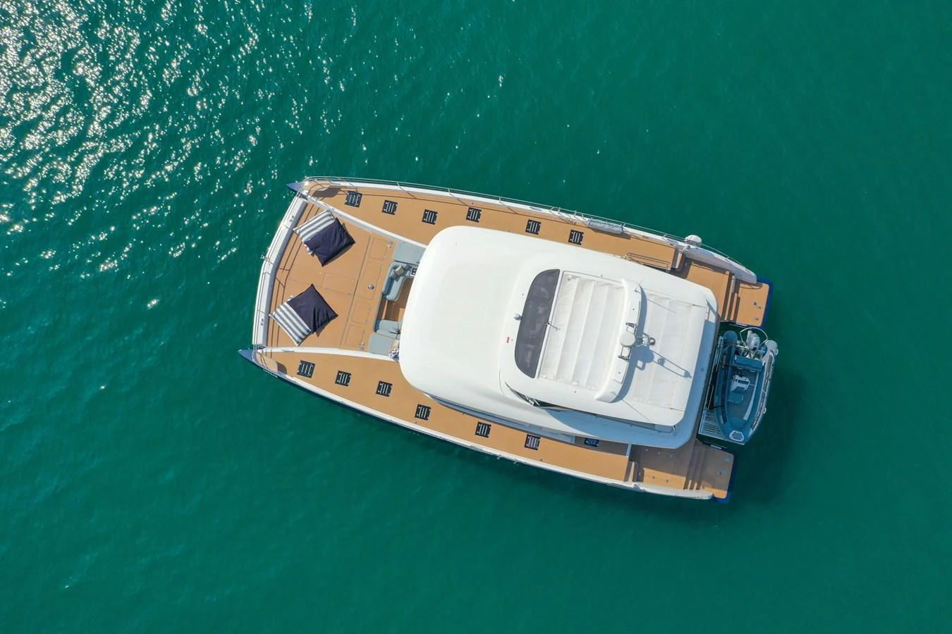 An aerial view of a sleek yacht cruising on clear turquoise waters. aboard LAGOON SIXTY 7 Yacht for Sale