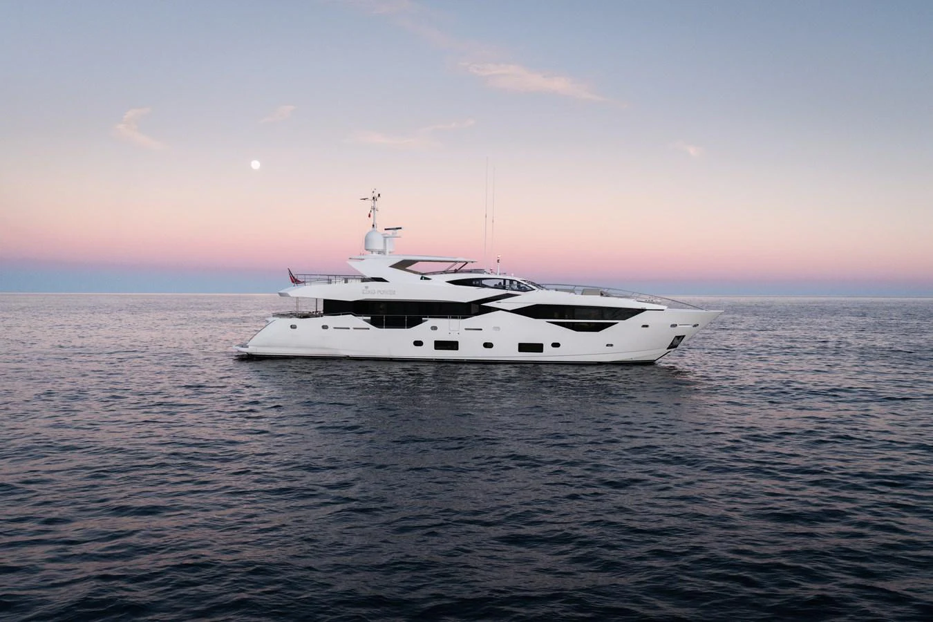 A sleek and modern yacht cruises gracefully on calm waters at sunset. aboard KING POWER Yacht for Sale