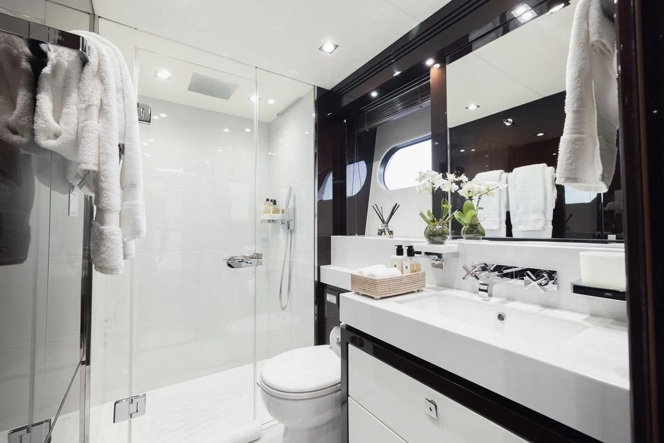 The yacht's bathroom features a sleek, modern design with a glass-enclosed shower and elegant fixtures. aboard KING POWER Yacht for Sale