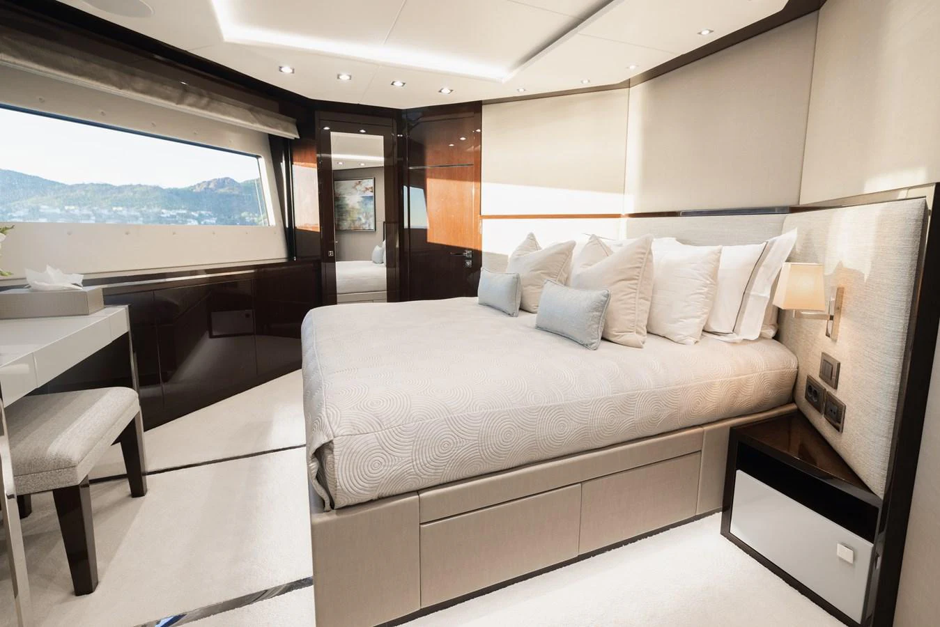 The stateroom features a luxurious bed with ample natural light and elegant furnishings. aboard KING POWER Yacht for Sale