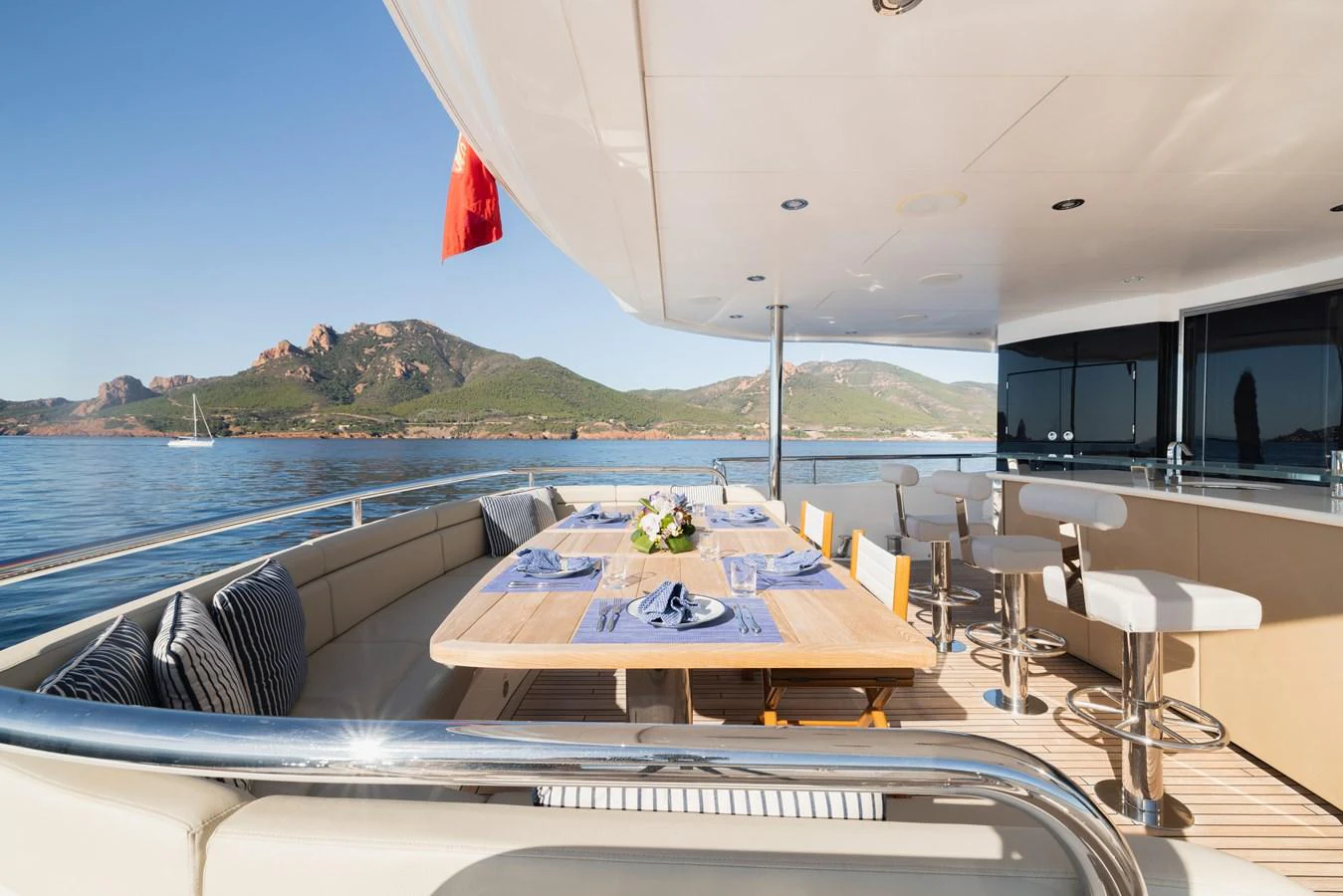The aft deck features a stylish dining area with scenic views of the water and surrounding landscape. aboard KING POWER Yacht for Sale