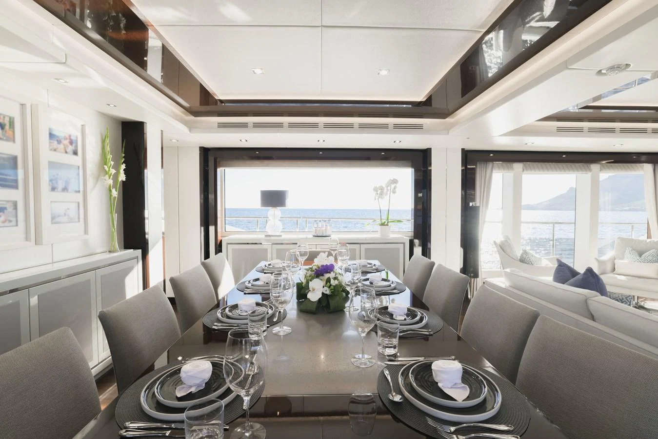 The yacht's dining area features a beautifully set table with an elegant and modern design, offering stunning views of the sea. aboard KING POWER Yacht for Sale