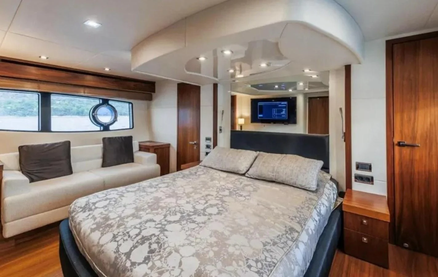 a bedroom with a bed and a tv on the wall aboard 2 DRUNK Yacht for Sale