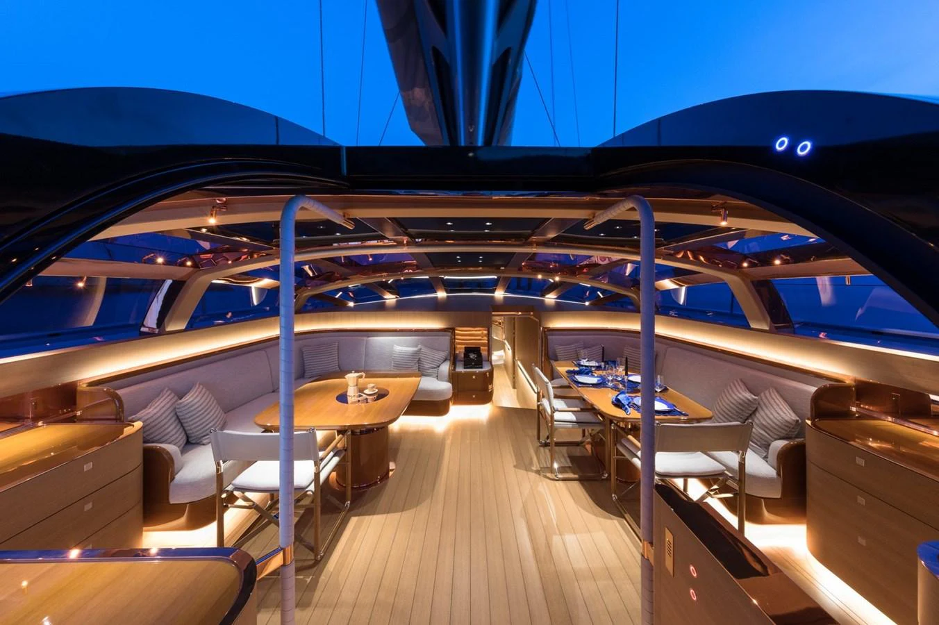 The yacht's salon features elegant seating and dining areas with ambient lighting and panoramic views. aboard ANOMALY Yacht for Sale