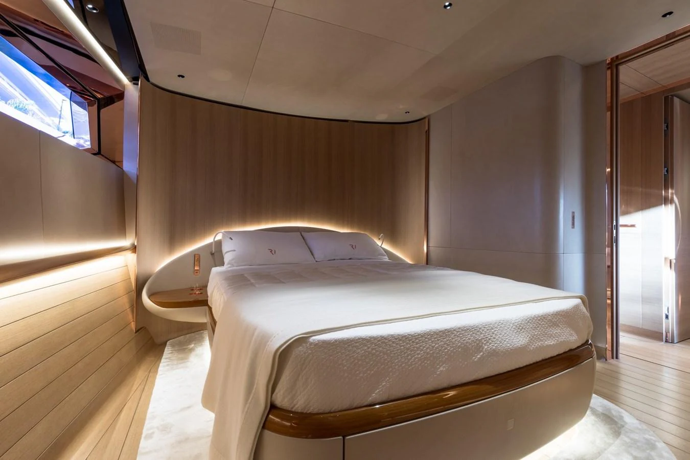 The stateroom features a luxurious bed with elegant lighting and modern design elements. aboard ANOMALY Yacht for Sale