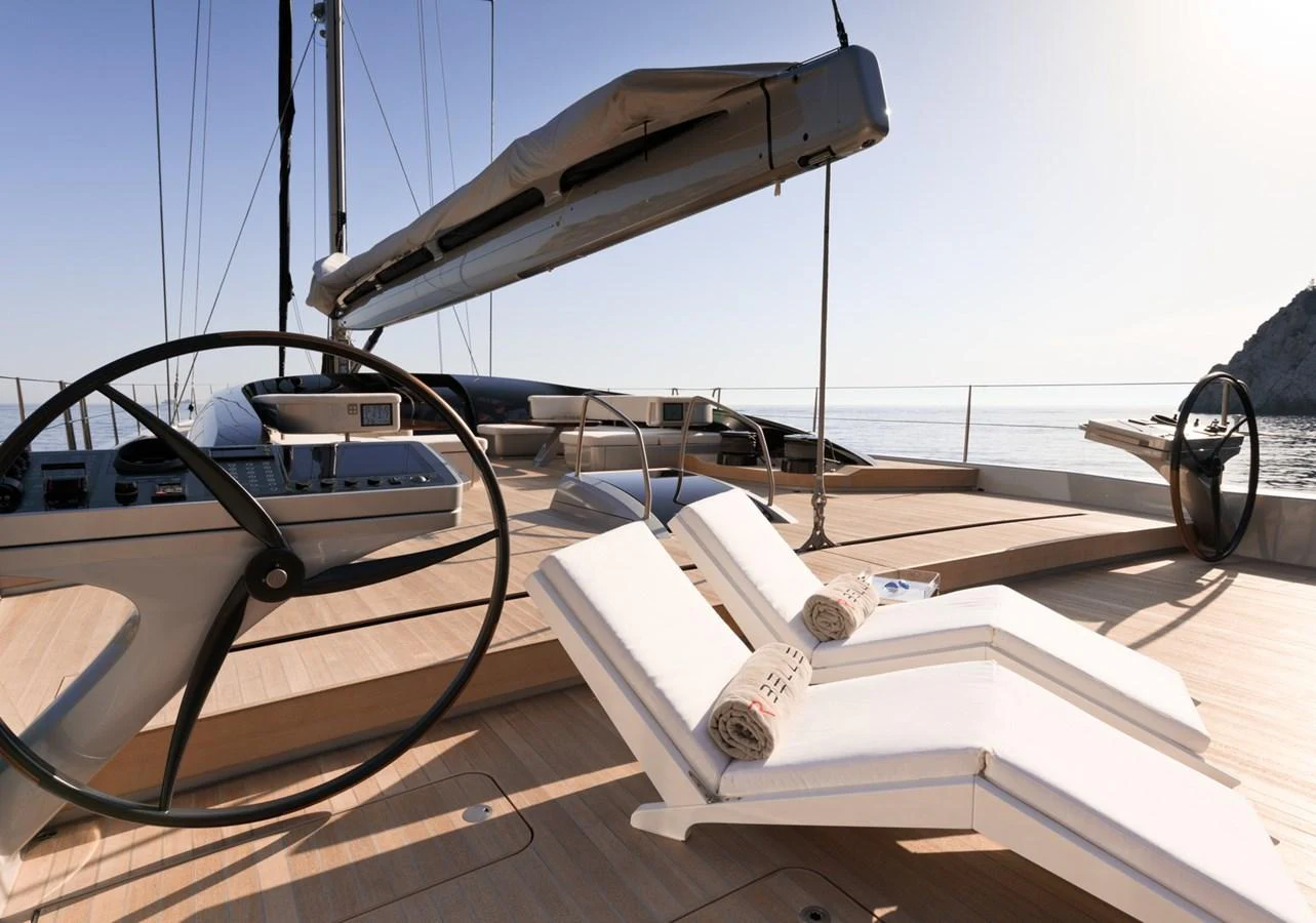The yacht's deck features luxurious sun loungers and a sleek helm station, perfect for relaxation and navigation. aboard ANOMALY Yacht for Sale