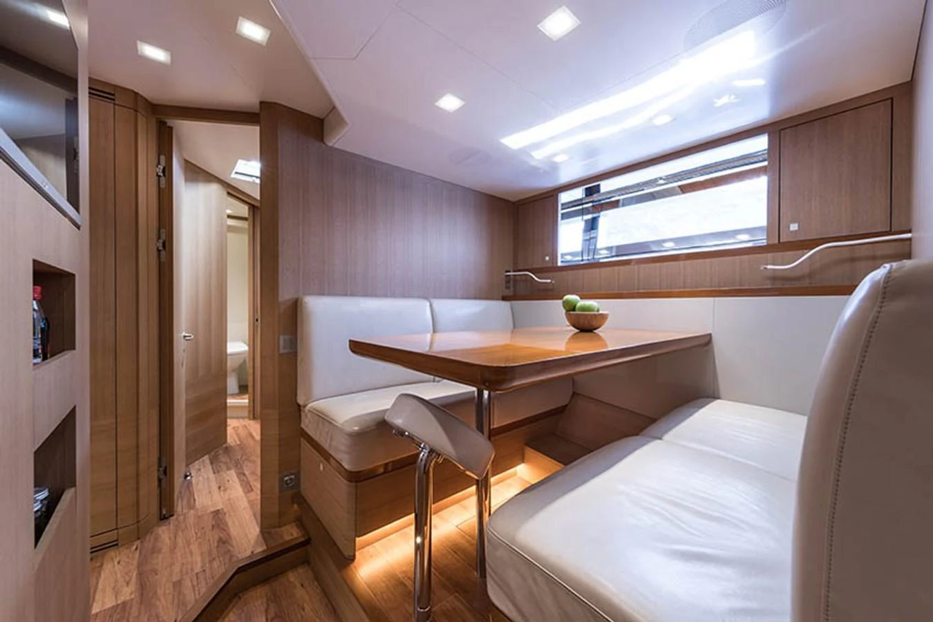 A cozy dining area with a wooden table and comfortable seating. aboard ANOMALY Yacht for Sale