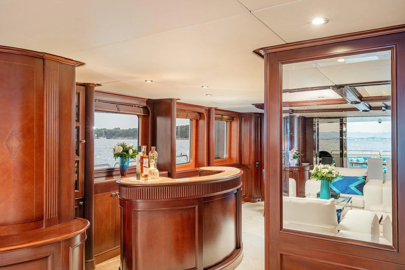 The yacht's salon features elegant wood paneling and a cozy bar area, creating a warm and inviting atmosphere. aboard BANG! Yacht for Sale