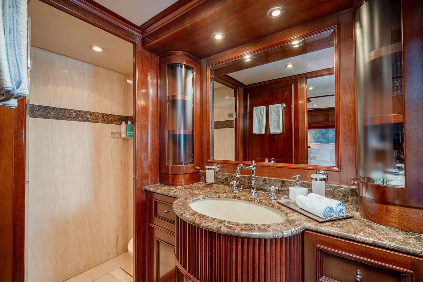 The bathroom features elegant wood paneling, a marble countertop, and modern fixtures. aboard BANG! Yacht for Sale