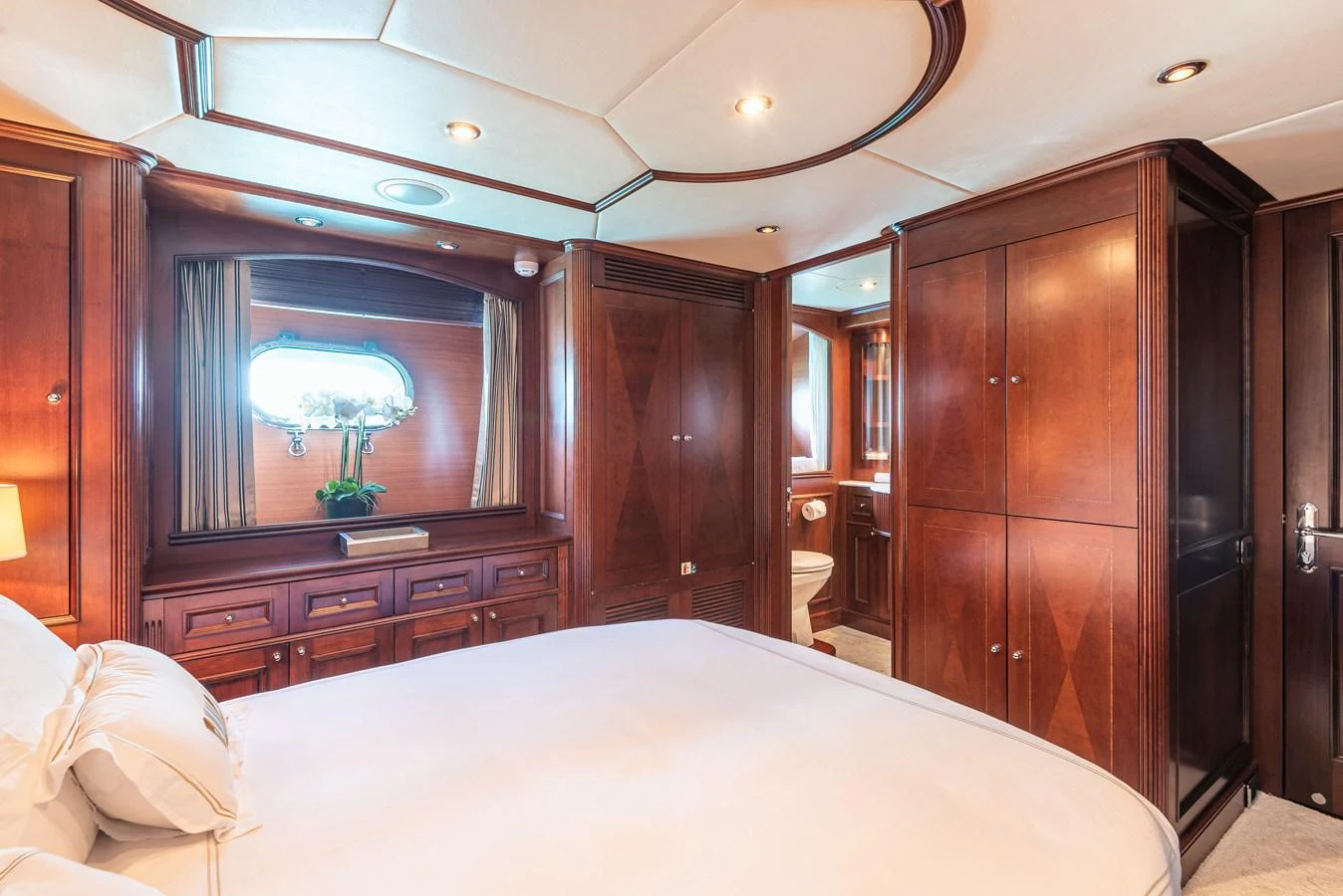 The stateroom features elegant wood paneling and a plush bed, creating a warm and inviting atmosphere. aboard BANG! Yacht for Sale