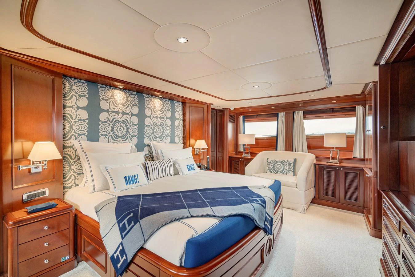 The master stateroom features luxurious wood paneling, a plush bed, and elegant decor. aboard BANG! Yacht for Sale