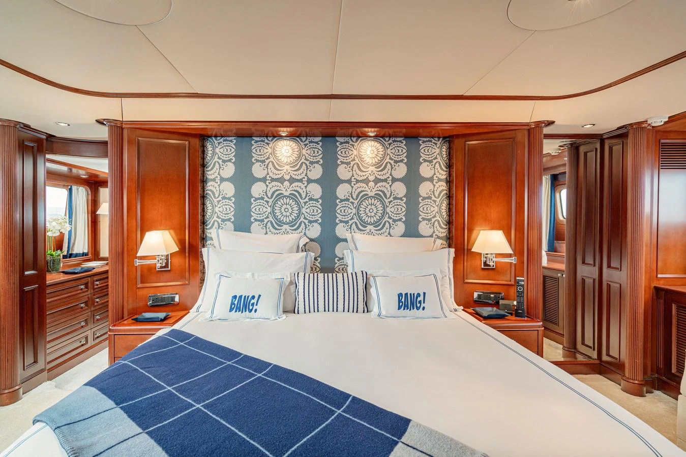 The master stateroom features a luxurious bed with elegant wood paneling and stylish decor. aboard BANG! Yacht for Sale