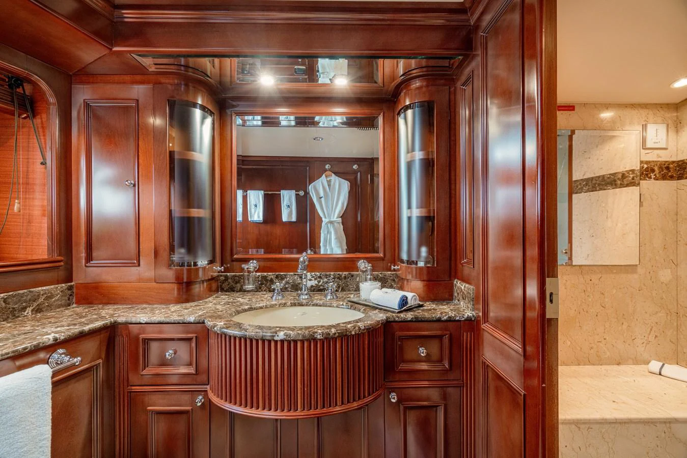 The yacht's bathroom features elegant wood cabinetry and a luxurious marble countertop. aboard BANG! Yacht for Sale
