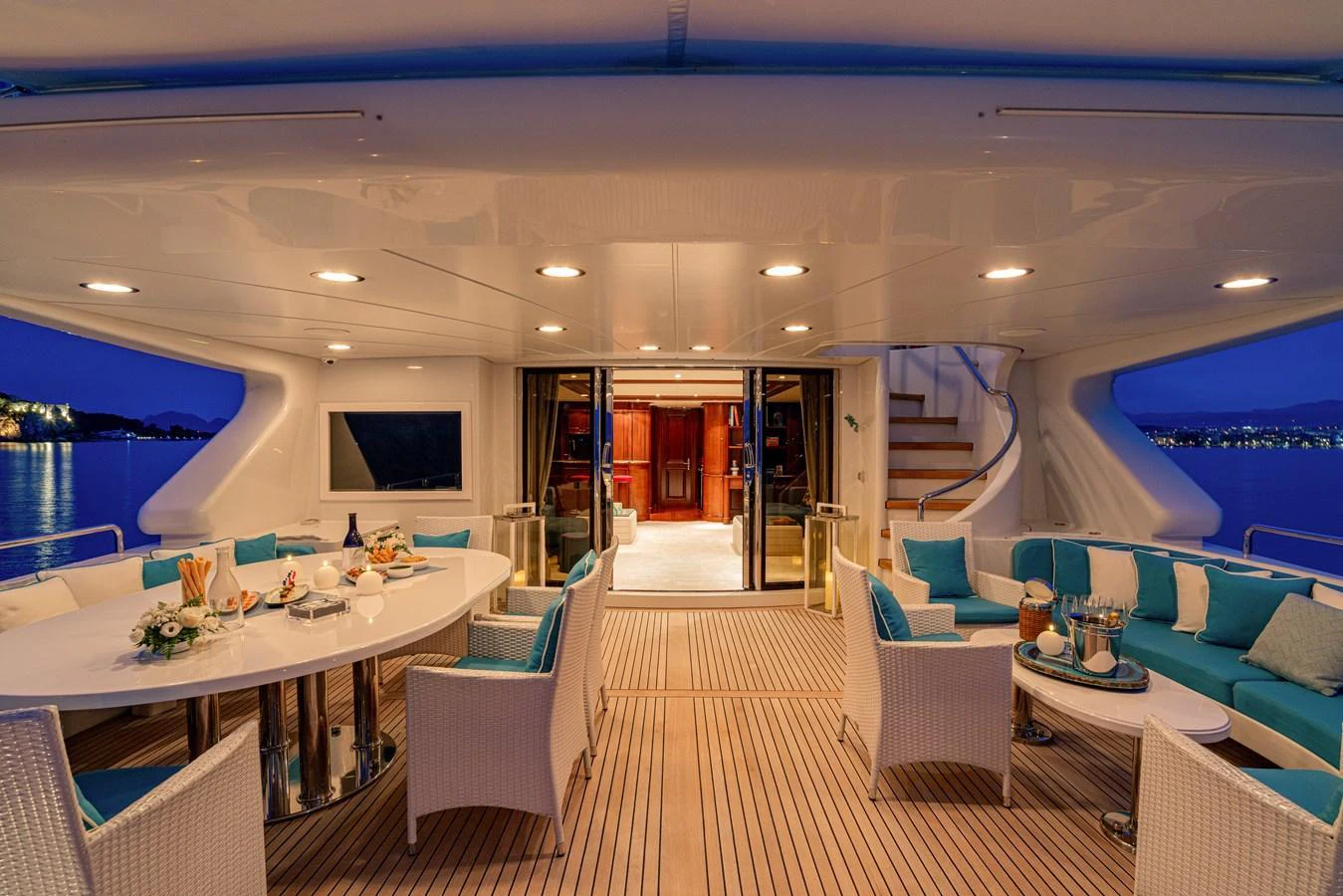 The aft deck offers a luxurious outdoor dining and lounging area with elegant furnishings and ambient lighting. aboard BANG! Yacht for Sale