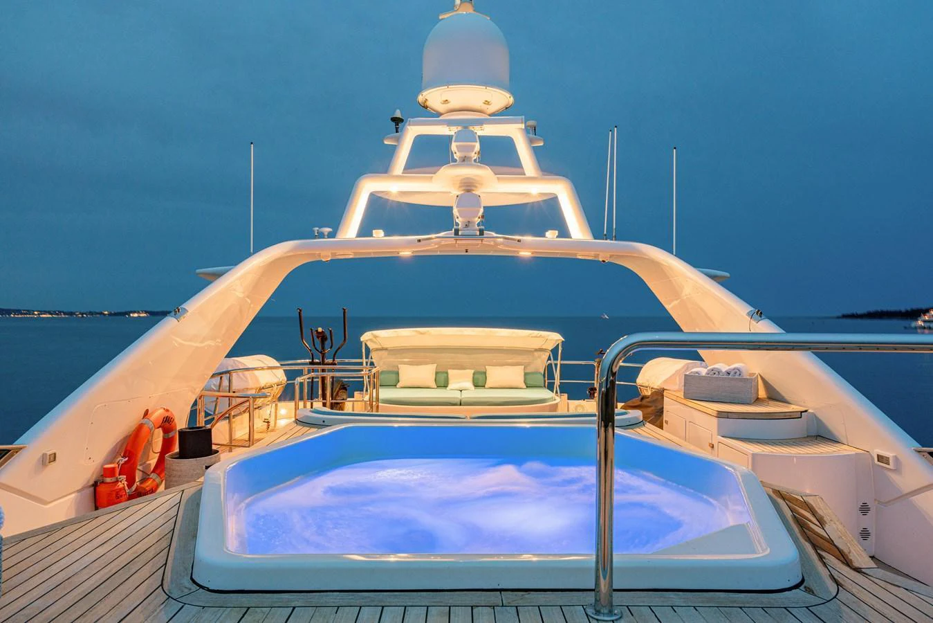 The sundeck features a luxurious jacuzzi with ambient lighting, perfect for relaxation under the evening sky. aboard BANG! Yacht for Sale