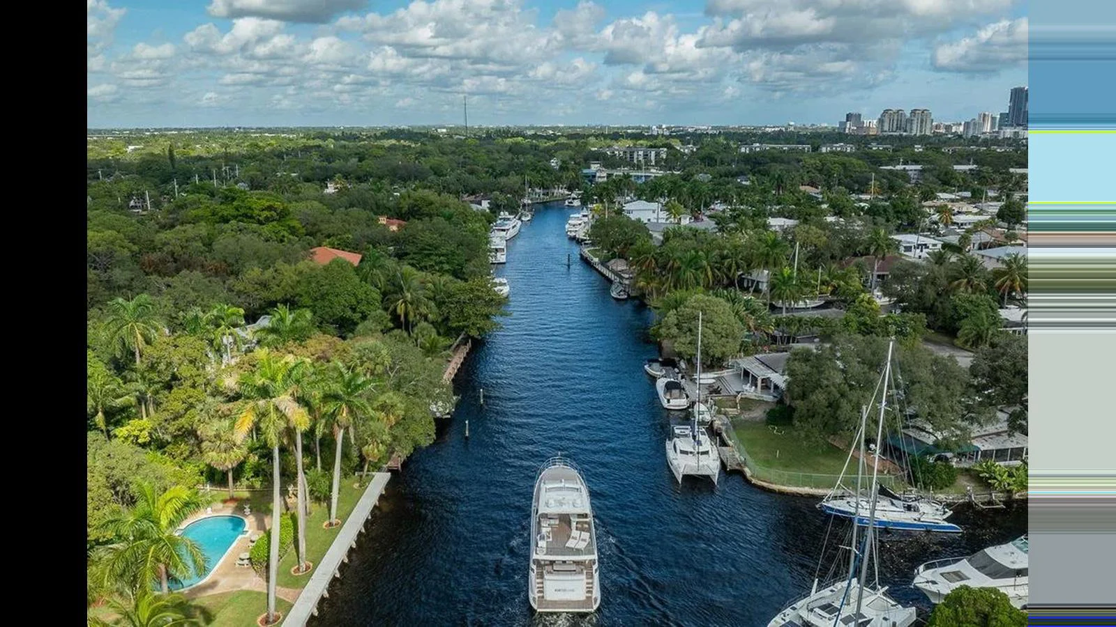 A yacht navigates through a scenic waterway surrounded by lush greenery and residential properties. aboard 2022 AZIMUT GRANDE 25 METRI Yacht for Sale