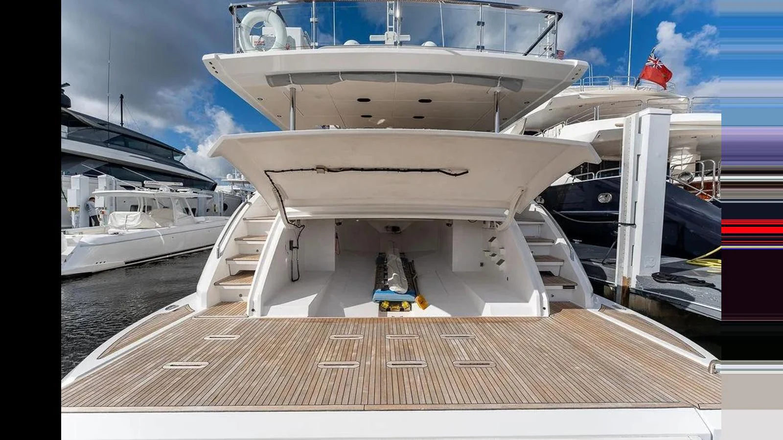 The yacht's aft deck features a spacious area with a wooden platform and steps leading up to the main deck. aboard 2022 AZIMUT GRANDE 25 METRI Yacht for Sale