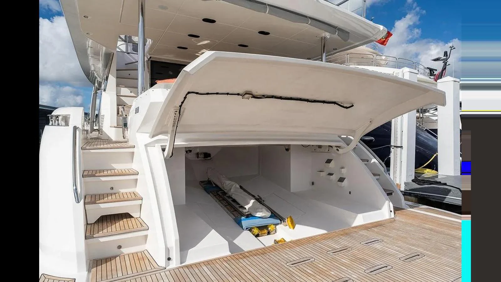 The yacht's garage is open, revealing storage space for water toys and equipment. aboard 2022 AZIMUT GRANDE 25 METRI Yacht for Sale