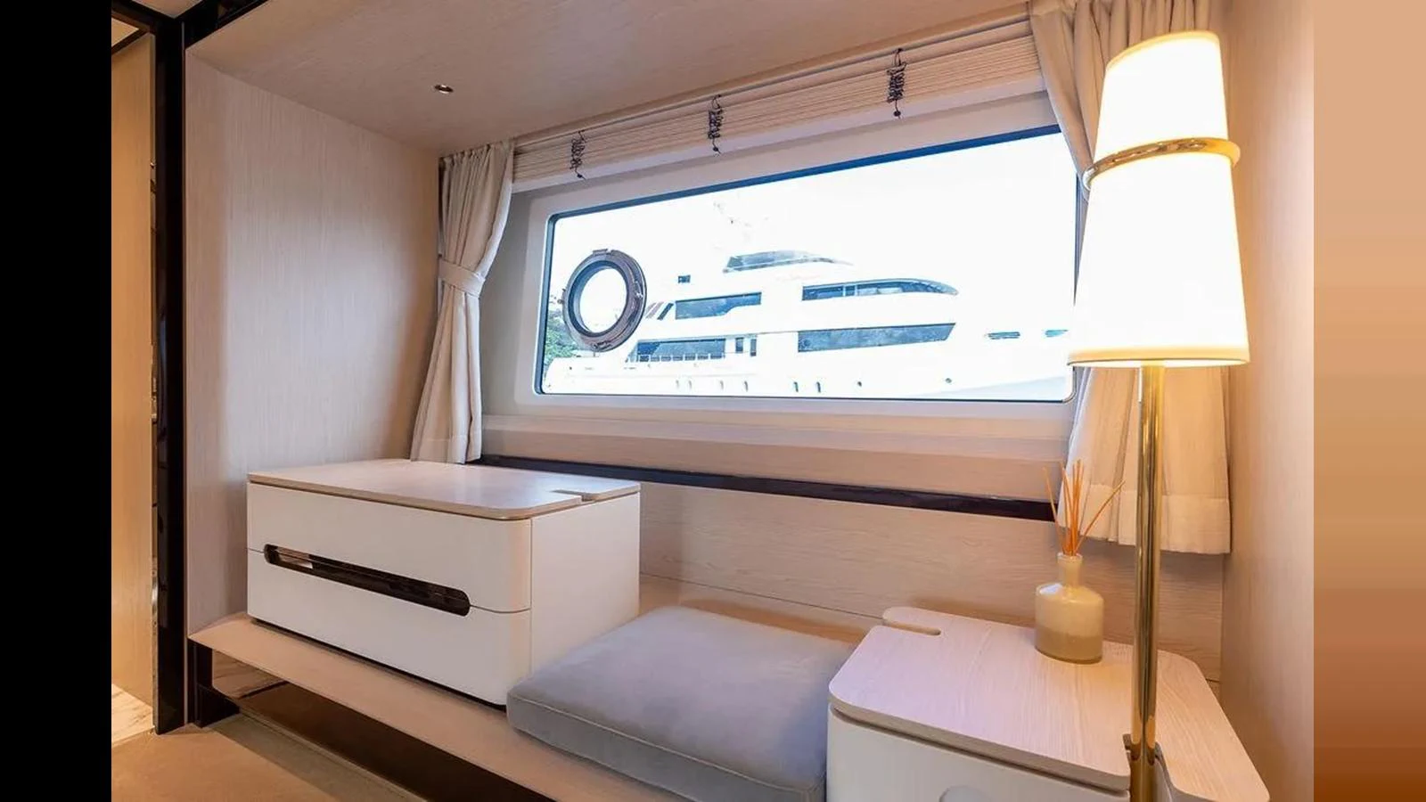 A serene interior space with a large window offering a view of another yacht outside. aboard 2022 AZIMUT GRANDE 25 METRI Yacht for Sale