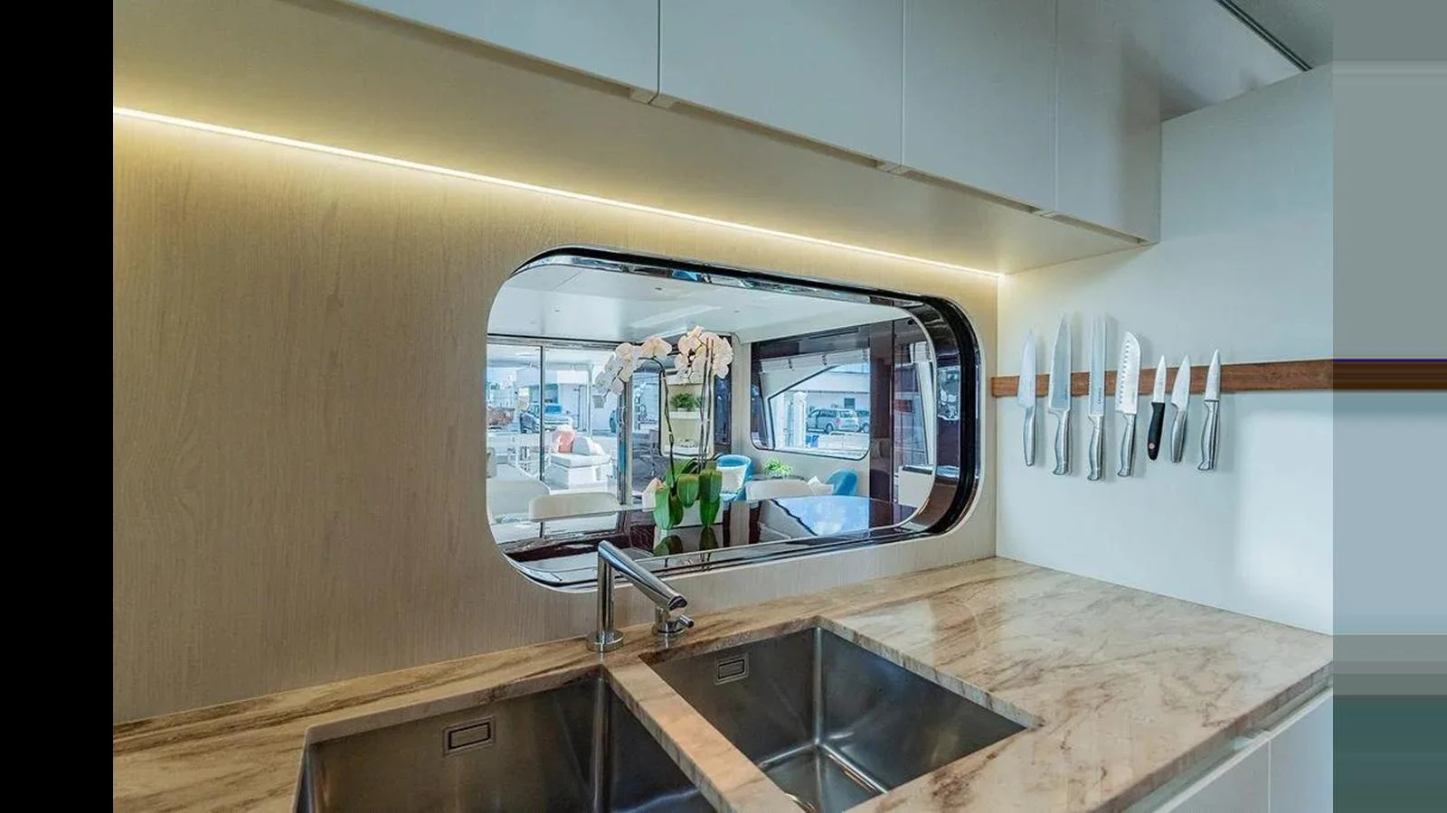 The yacht's galley features a sleek, modern design with a large window providing a view of the salon. aboard 2022 AZIMUT GRANDE 25 METRI Yacht for Sale