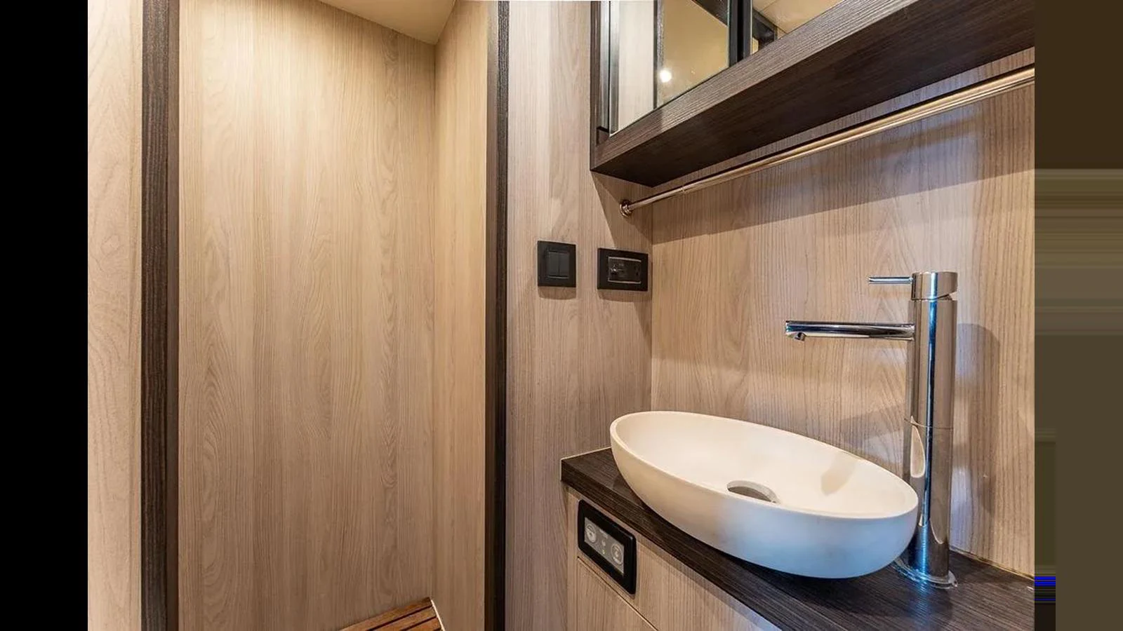 The yacht's bathroom features a modern sink and sleek wooden finishes. aboard 2022 AZIMUT GRANDE 25 METRI Yacht for Sale