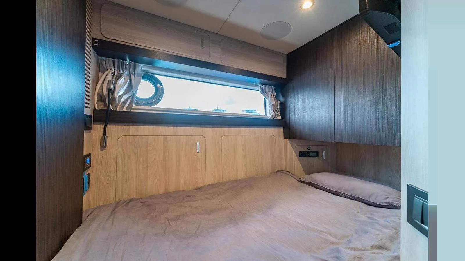 A cozy cabin with a large bed and a window providing natural light. aboard 2022 AZIMUT GRANDE 25 METRI Yacht for Sale