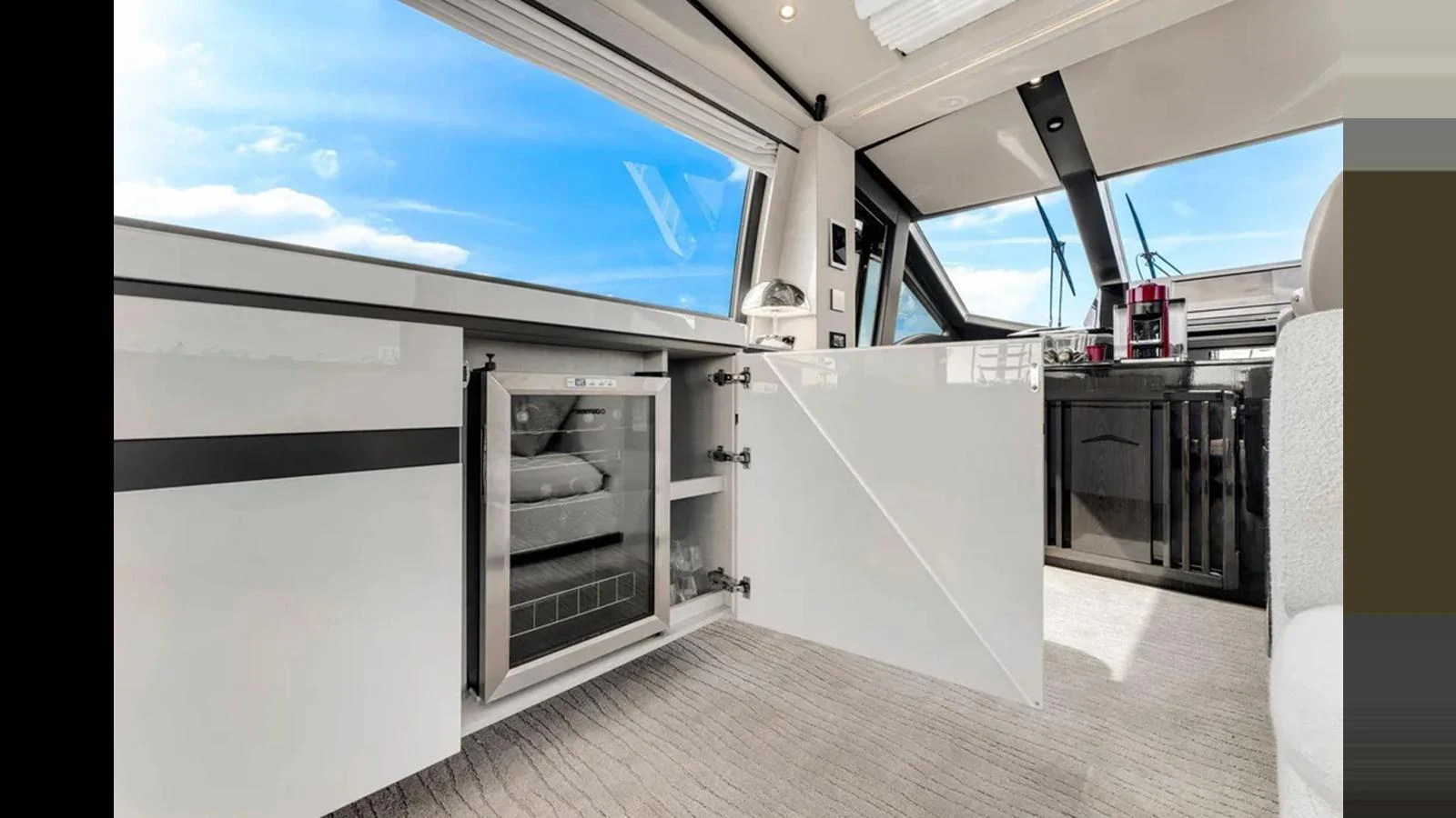 A modern yacht interior featuring a sleek kitchenette with a mini fridge and ample storage. aboard 2022 AZIMUT S10 Yacht for Sale