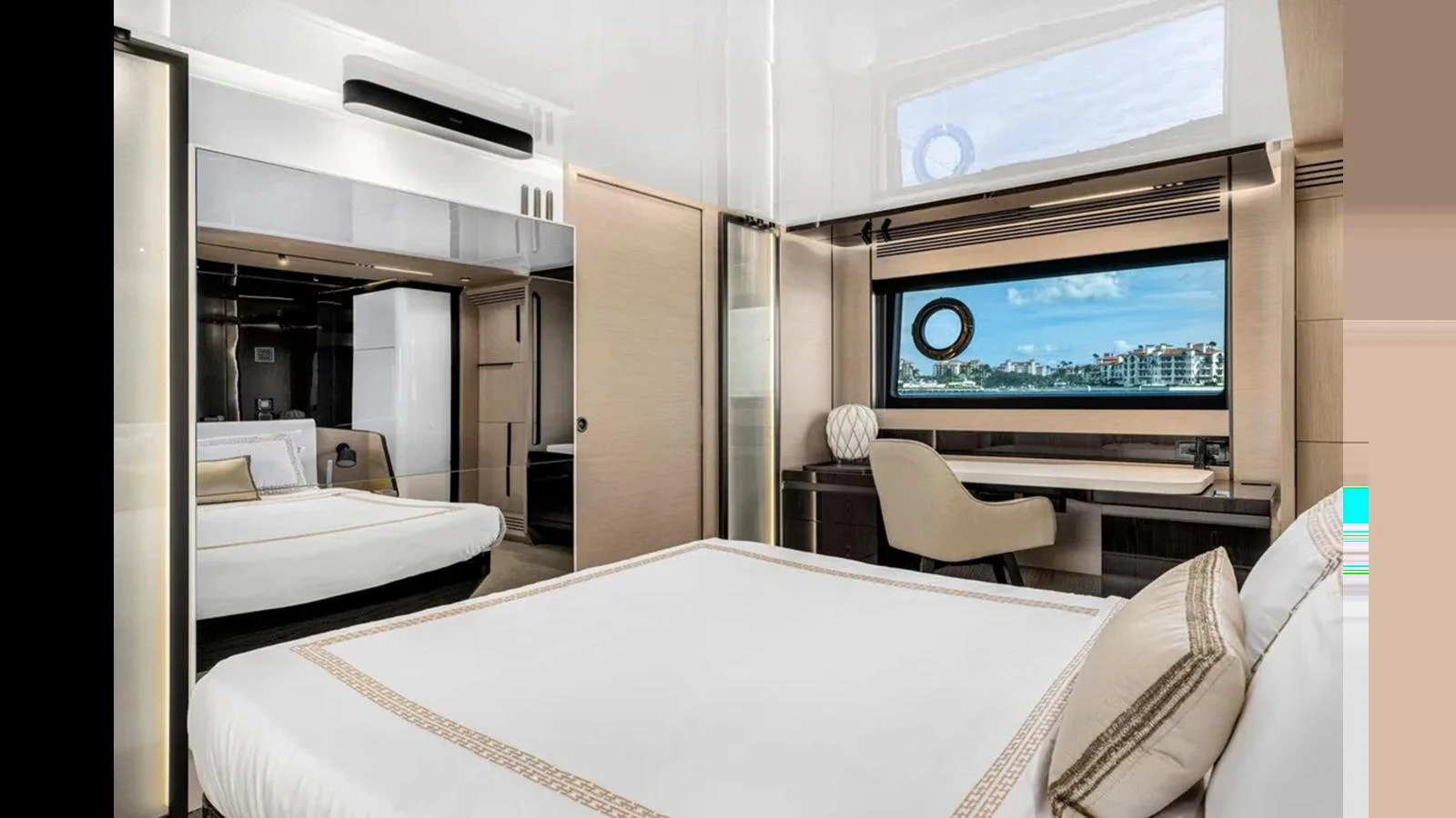 A luxurious stateroom featuring a large bed, a desk with a view, and modern decor. aboard 2022 AZIMUT S10 Yacht for Sale