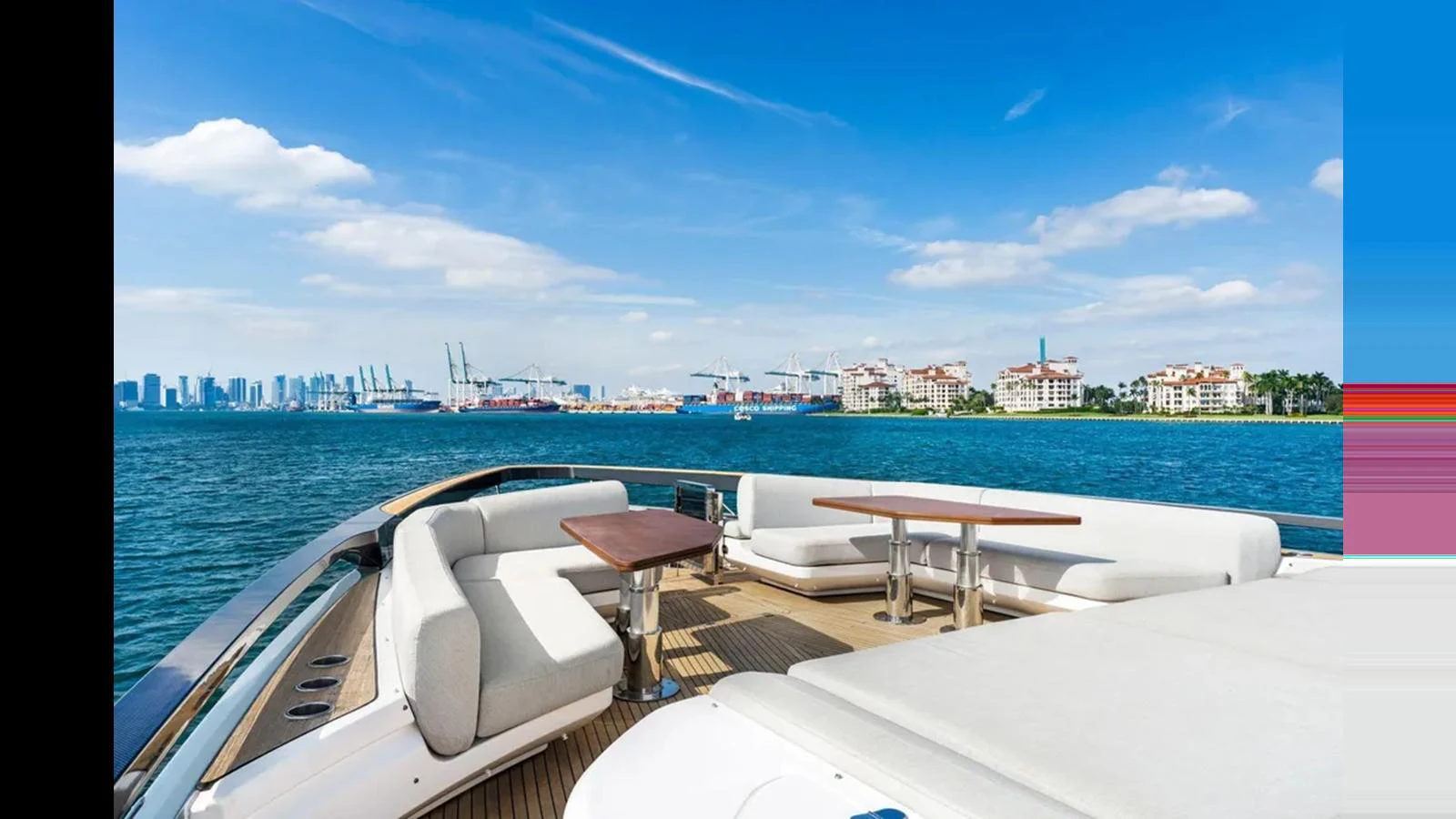 The yacht's flybridge offers a luxurious seating area with stunning views of the city skyline and harbor. aboard 2022 AZIMUT S10 Yacht for Sale