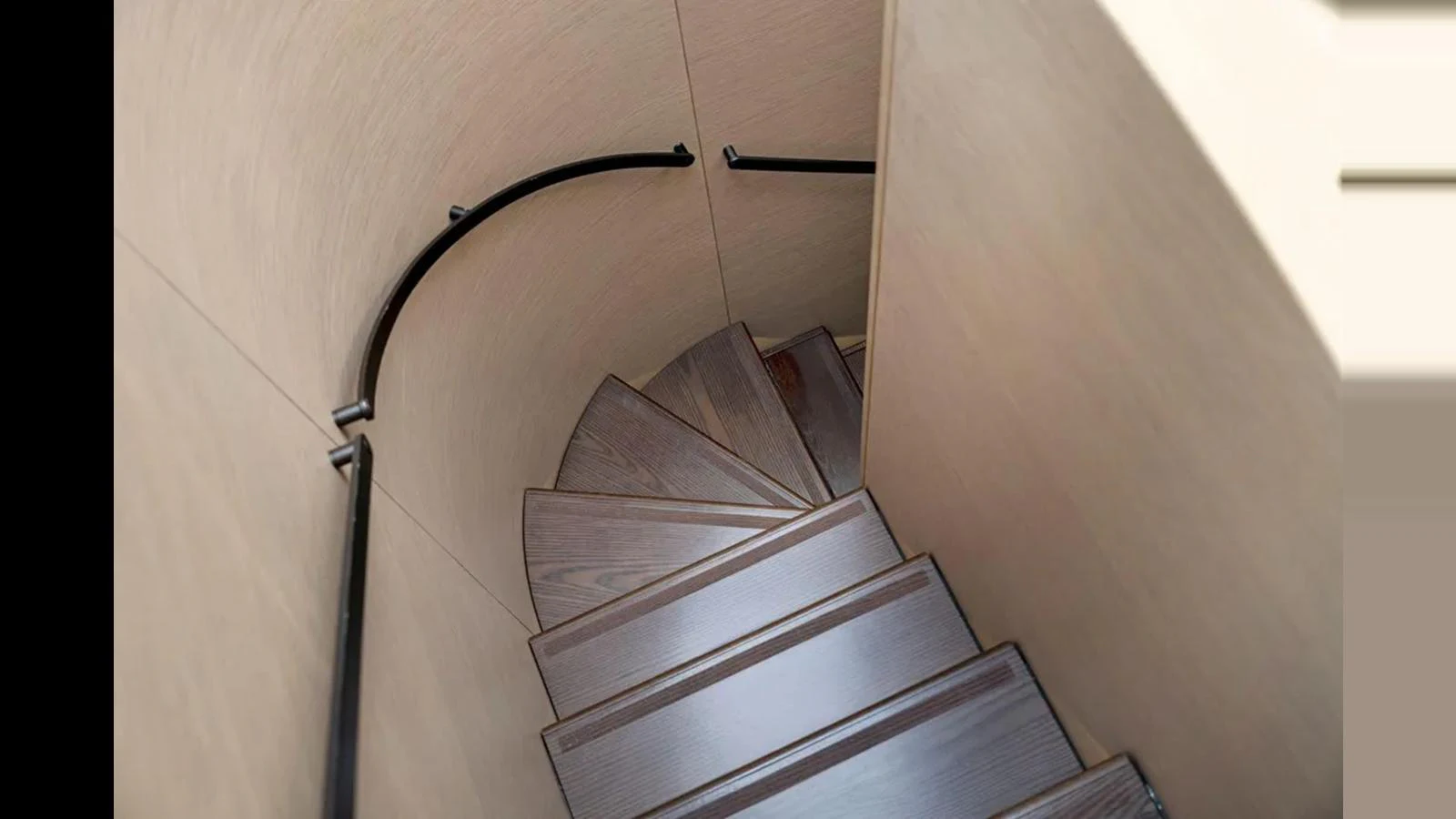 A sleek, modern spiral staircase with wooden steps and minimalist railings. aboard 2022 AZIMUT S10 Yacht for Sale