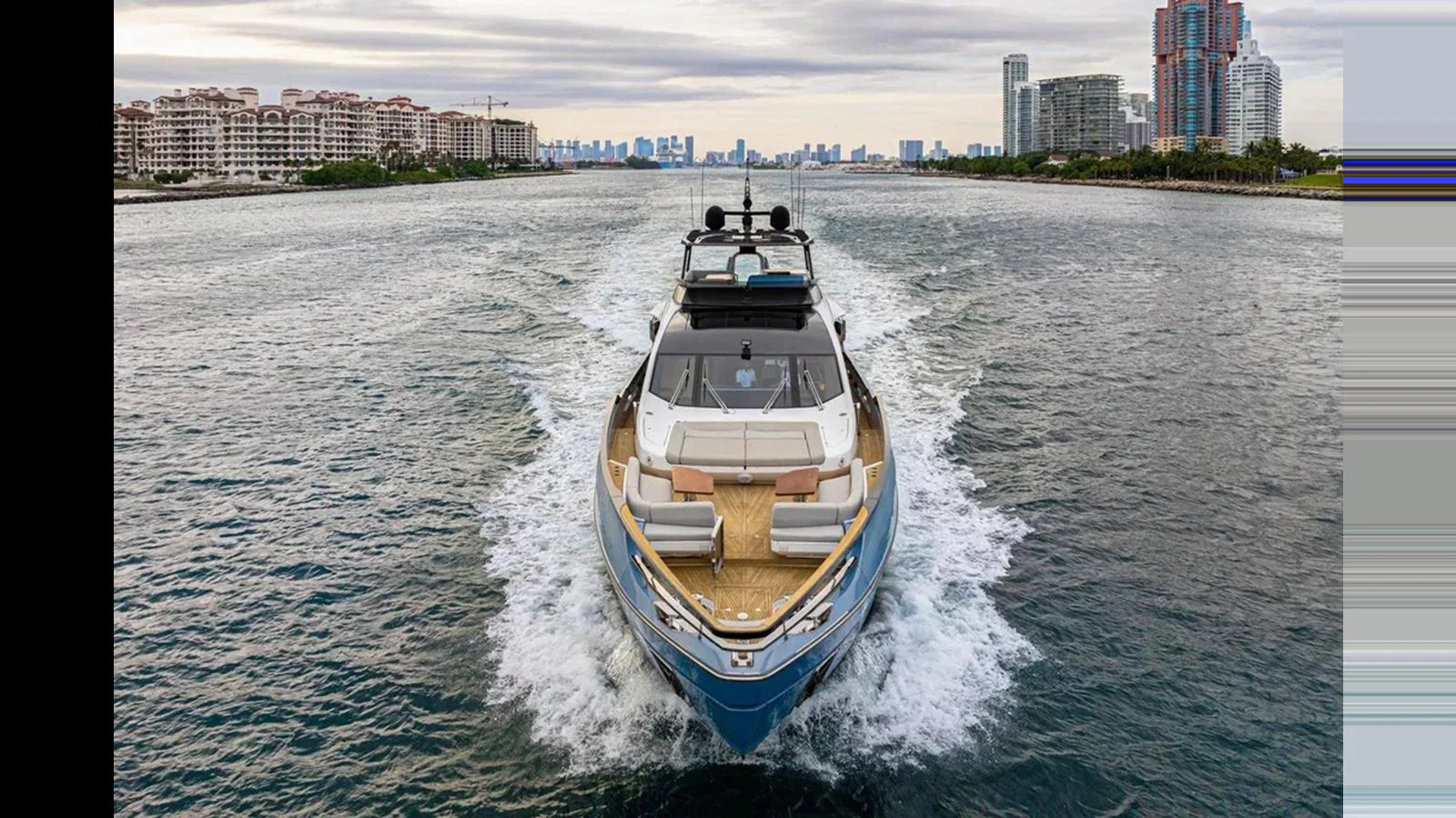 A sleek yacht cruises through the water with a cityscape in the background. aboard 2022 AZIMUT S10 Yacht for Sale