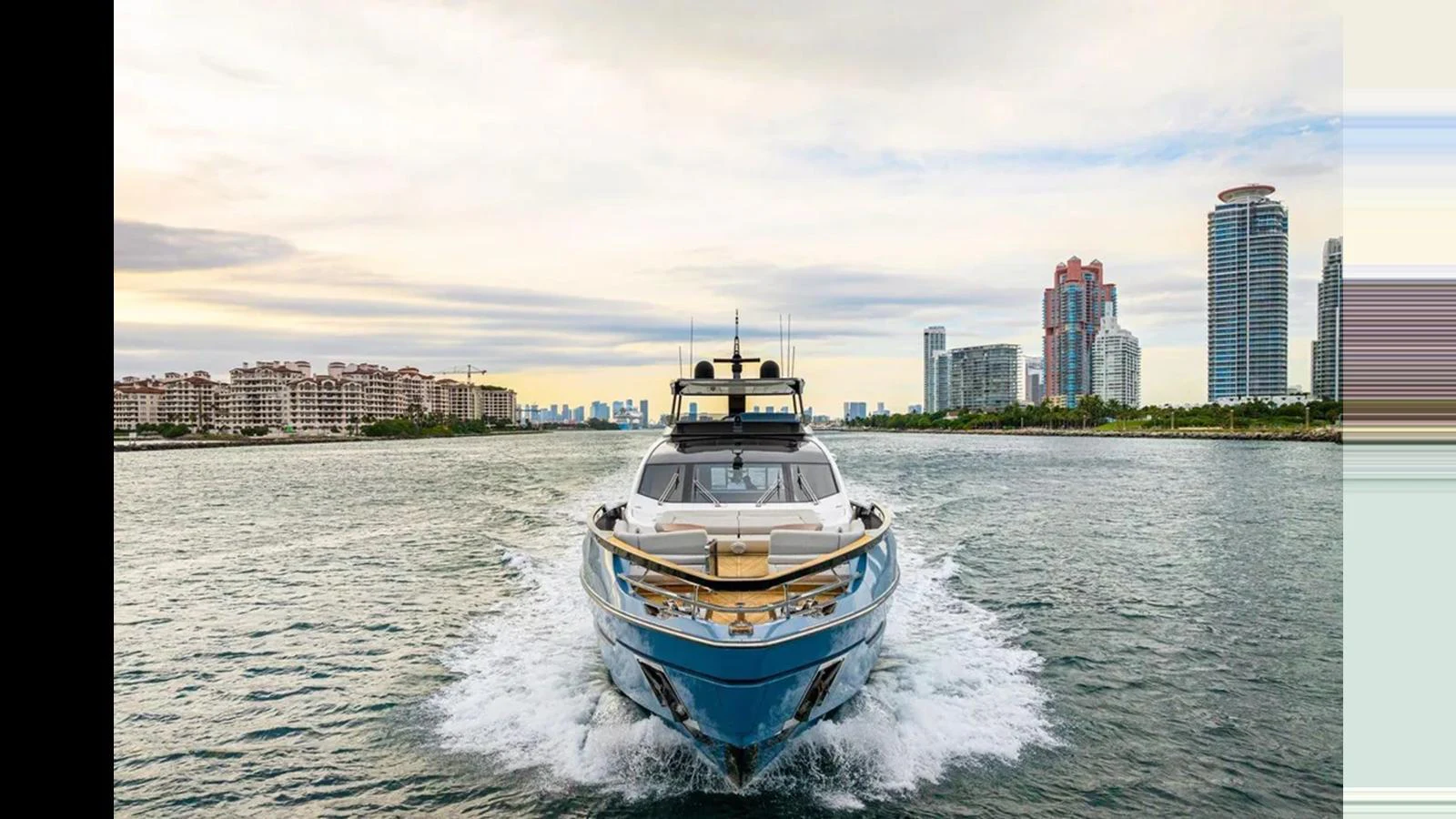 A sleek yacht cruises through the water with a cityscape in the background. aboard 2022 AZIMUT S10 Yacht for Sale