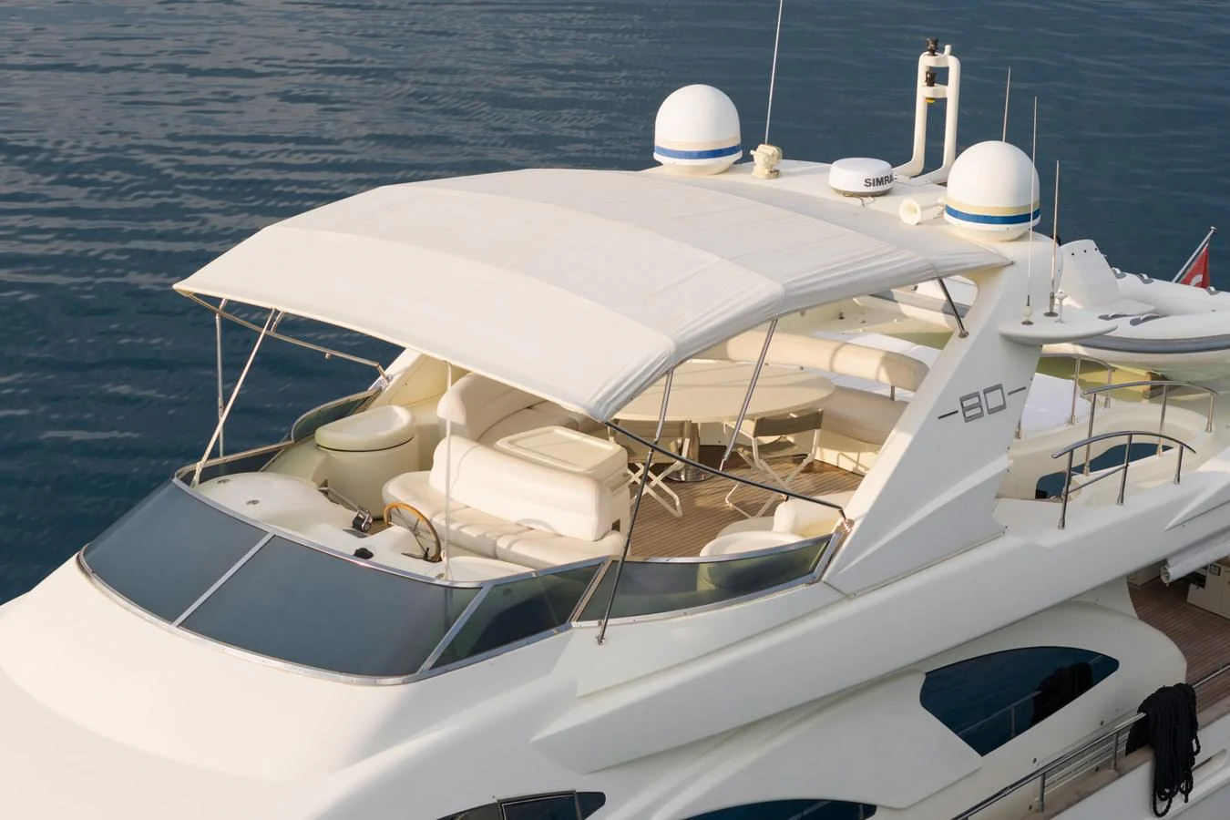 The yacht's flybridge offers a spacious and luxurious outdoor area with ample seating and a sleek canopy. aboard SENIOR S Yacht for Sale