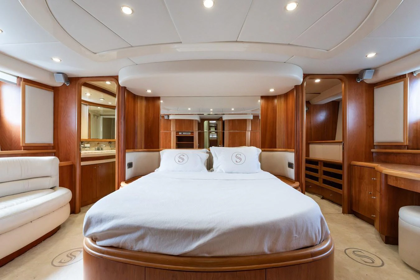 The master stateroom features a spacious bed with elegant wood paneling and ample natural light. aboard SENIOR S Yacht for Sale