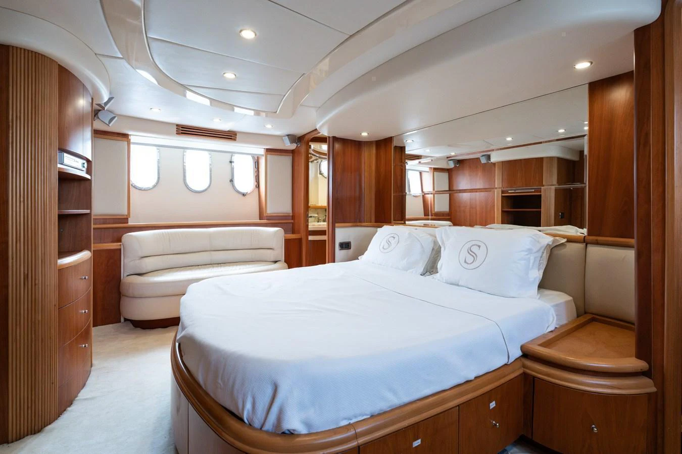 The master stateroom features a luxurious bed with elegant wood paneling and ample natural light. aboard SENIOR S Yacht for Sale