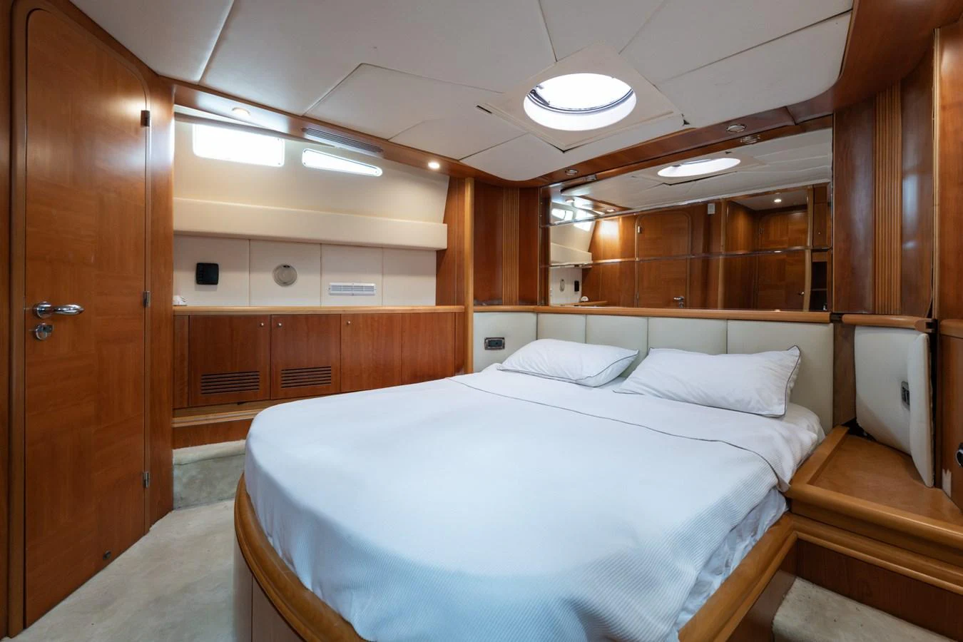 The master stateroom features a spacious bed, warm wood finishes, and ample storage. aboard SENIOR S Yacht for Sale